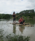 People cross the reservoir in bamboo rafts and wooden canoes after the submergence of the only bridge that connected the valley
