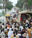 Soldiers help flood survivors board an evacuation truck