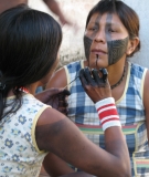 Kayapó women paint their faces in preparation