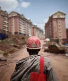 A labourer walks at a construction site where houses will be raised for people who will be relocated in Badong, on the banks of the Yangtze River, 100km (62 miles) from the Three Gorges dam in Hubei. 