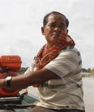 A Cambodian tourist boat owner drives his boat.
