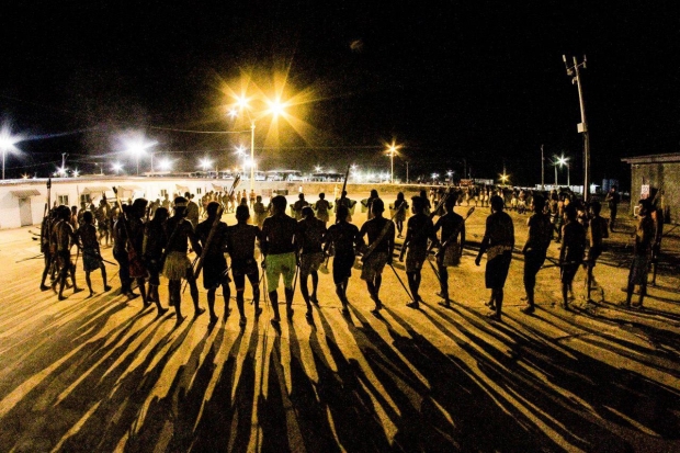 Warriors gather at night at the dam site.