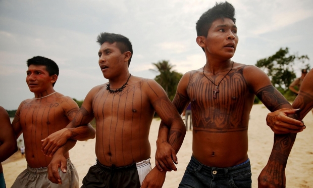 Members of the Munduruku indigenous tribe dance during a “Caravan of Resistance’” protest in São Luiz do Tapajós against plans to build a hydroelectric dam on 27 November 2014. 