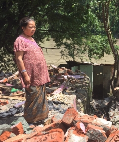 Meena Sherpa standing at her now demolished home. She has refused the merge compensation offered. 