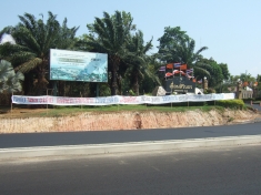 At the main entrance to Sirindhorn Dam, a protest banner denounces a proposed nuclear power station, claiming it will further destroy livelihoods of local dam-affected people.