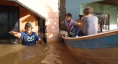 A family decries the dam consortia outside their flooded home in Porto Velho.