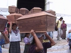 Women carry mock coffins in protest.