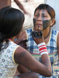 Kayapó women paint their faces in preparation