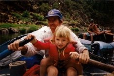Rebecca rowing on her dads lap as a little girl