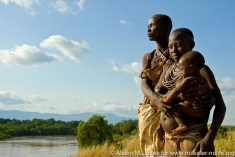 Three generations of women looking out over the Omo River.