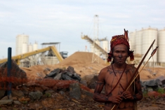 A lone warrior stands in front of the occupied construction site of the Belo Monte Dam in the Brazilian Amazon.