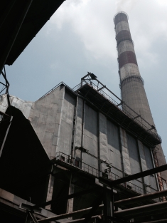 The chimney of Line 1 of the Phả Lại Power Station looms in the background. Line 1 doesn't have flue-gas desulfurization installed to capture sulfur emissions, causing major health issues for workers.