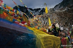 A pilgrim climbs through a tapestry of prayer flags. To circle Mount Kawagebo takes nearly two weeks.