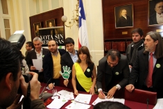 Candidates and legislators sign the Vota Sin Represas pledge on Monday at the former Congress building in Santiago